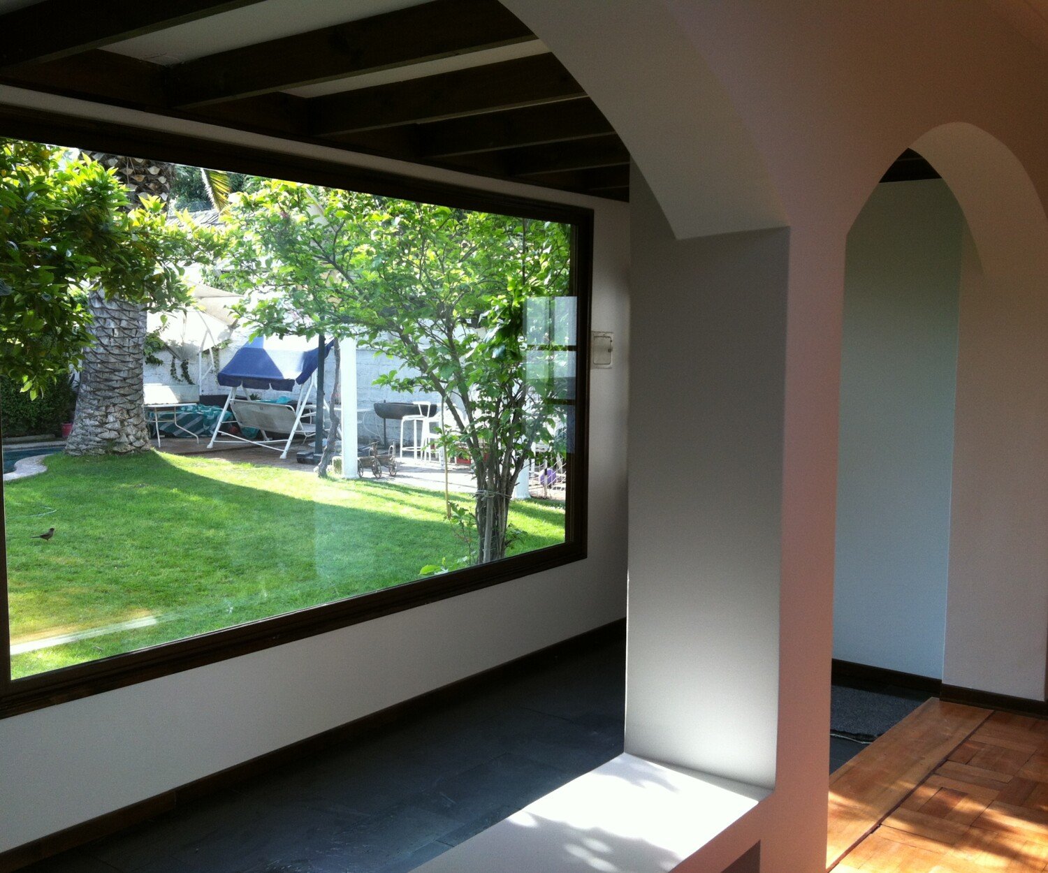 Living de Casa Arratia con tragaluz de madera y terraza hacia el jardín