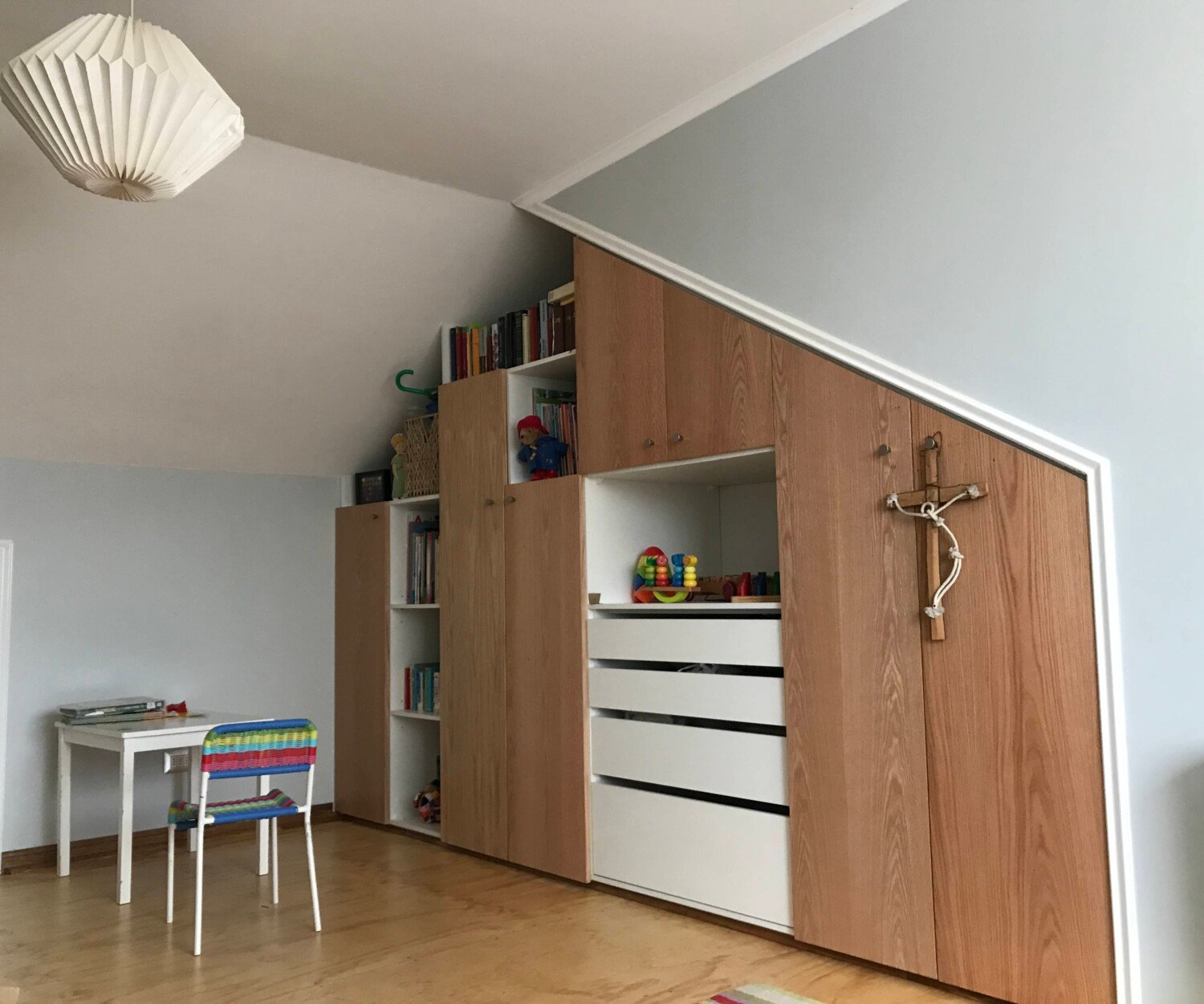 Cocina de Casa Narea bajo buhardilla con isla de cuarzo y taburetes pastel