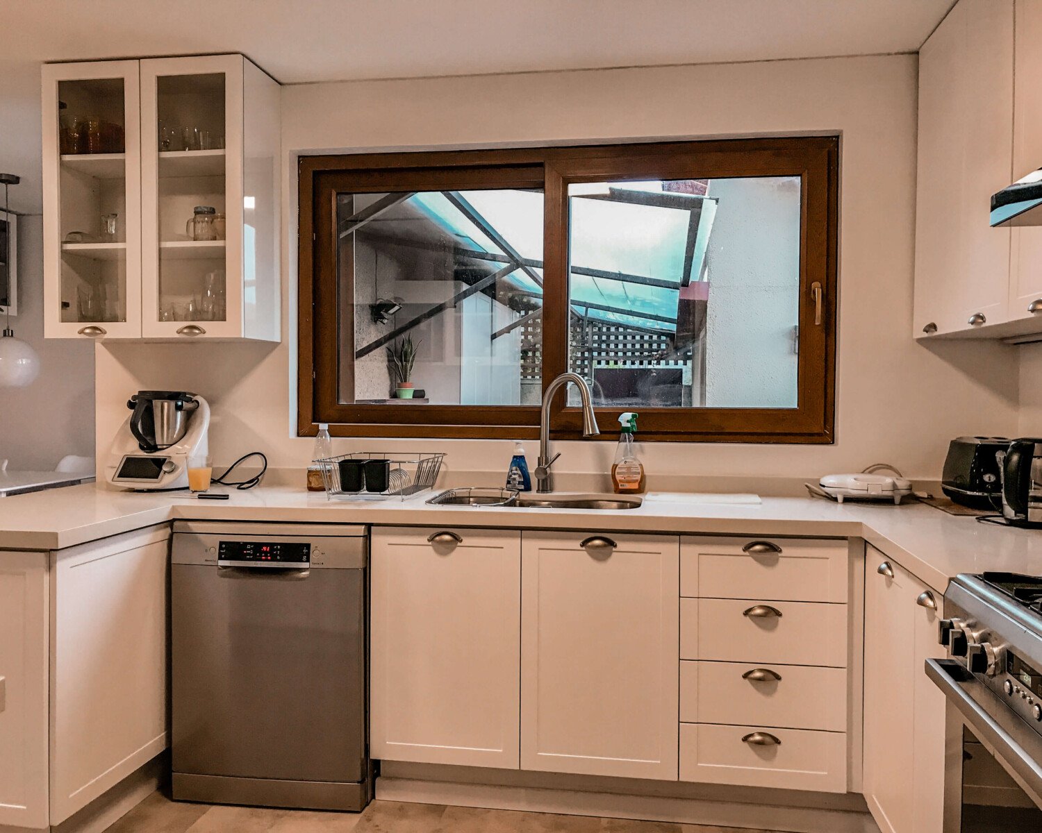 Living de Casa Solanes con repisas flotantes y mueble con herrajes dorados