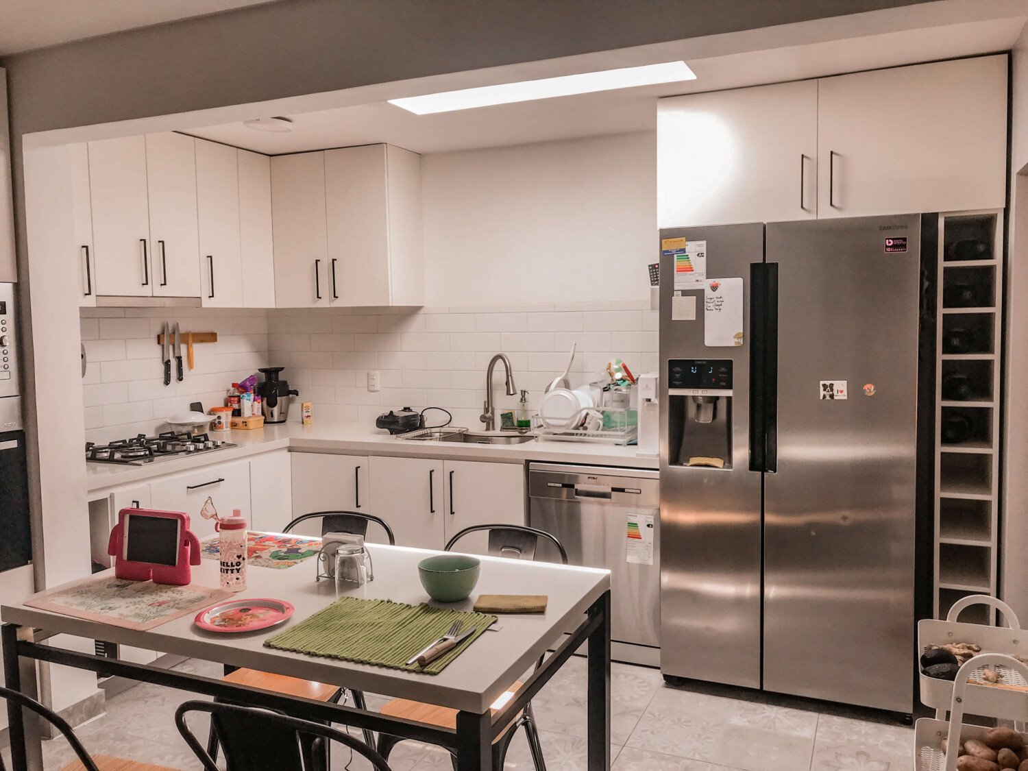 Cocina en L de Cocina Wijnant con comedor integrado y muebles blancos