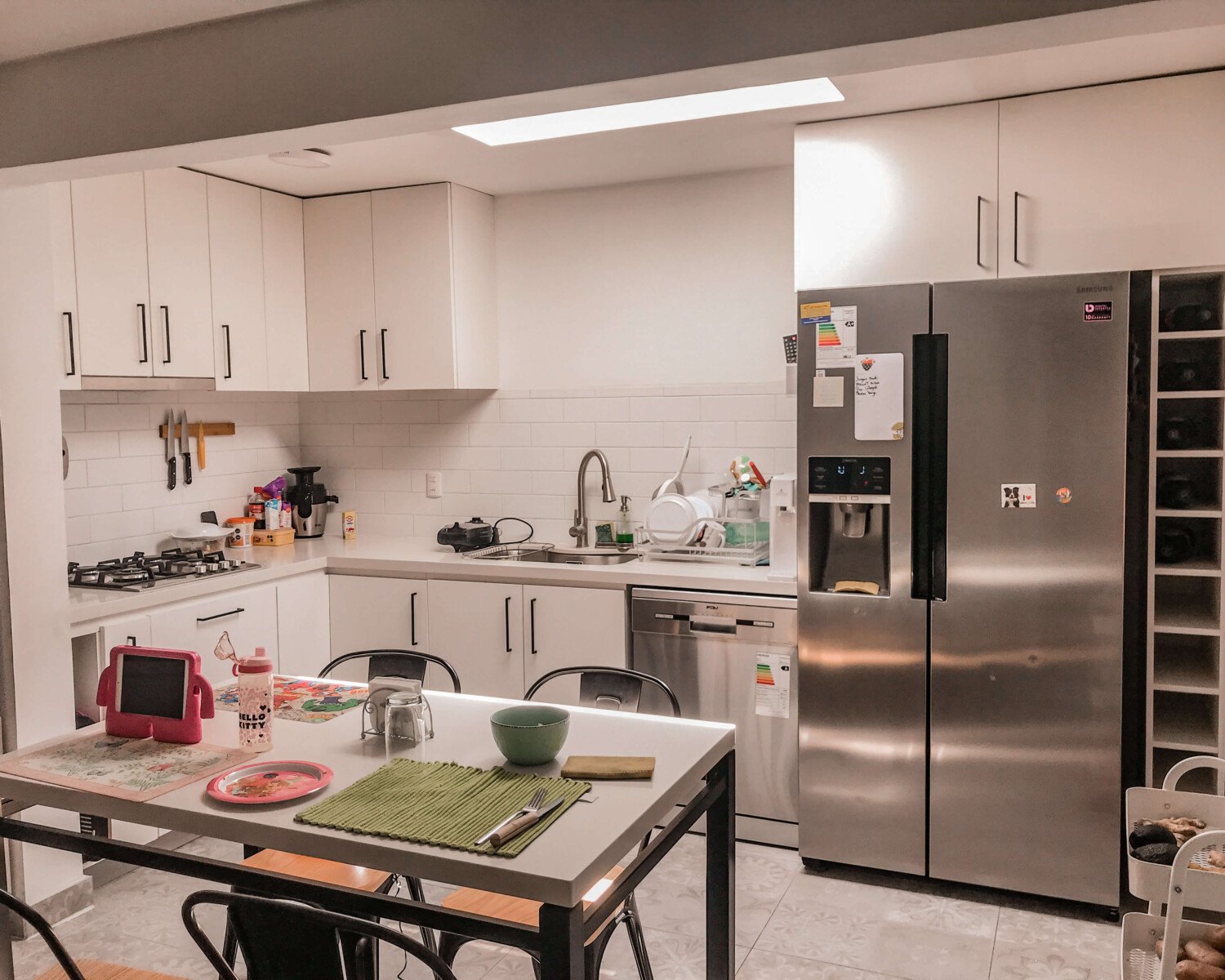 Cocina en L de Cocina Wijnant con comedor integrado y muebles blancos