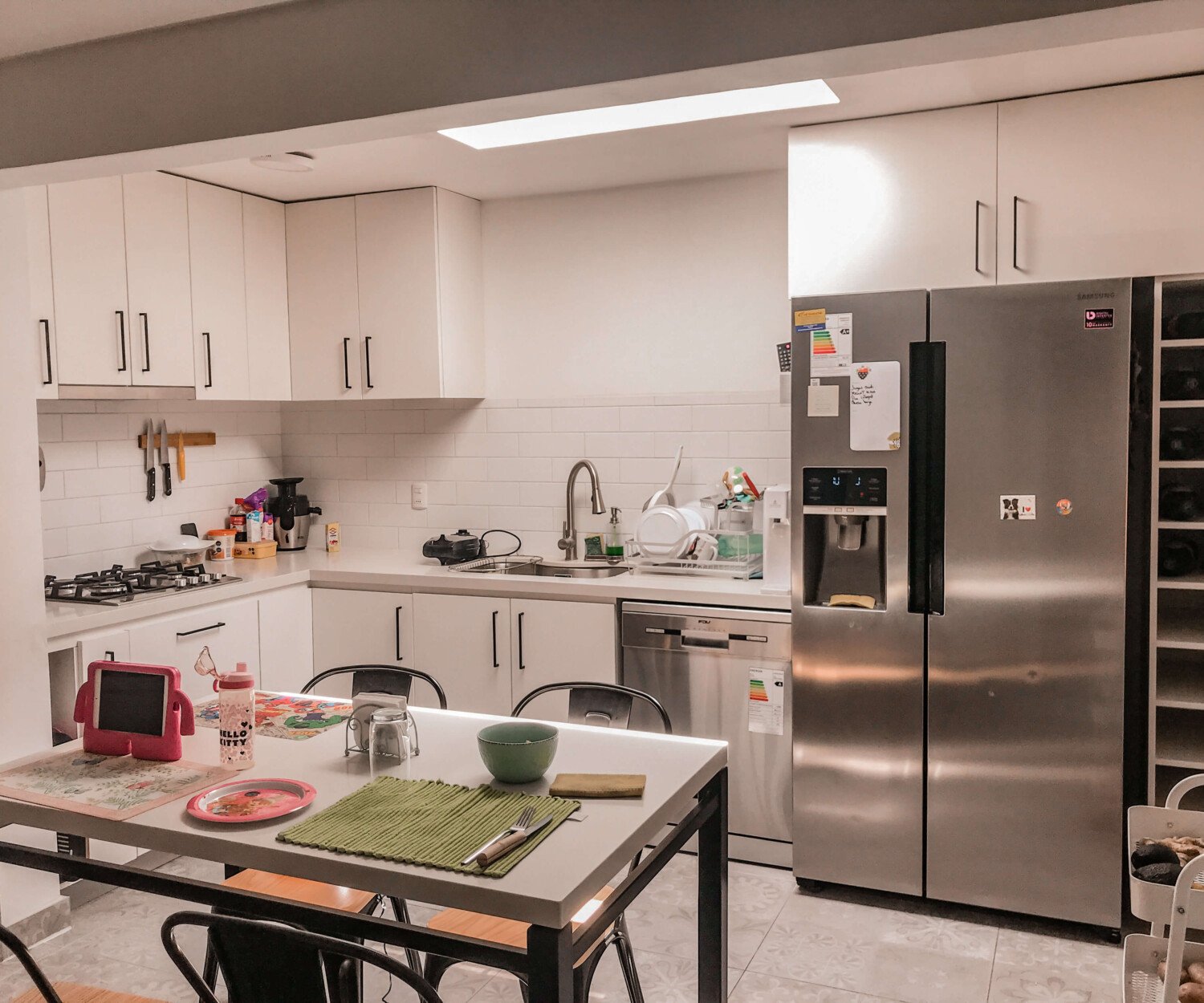 Cocina en L de Cocina Wijnant con comedor integrado y muebles blancos
